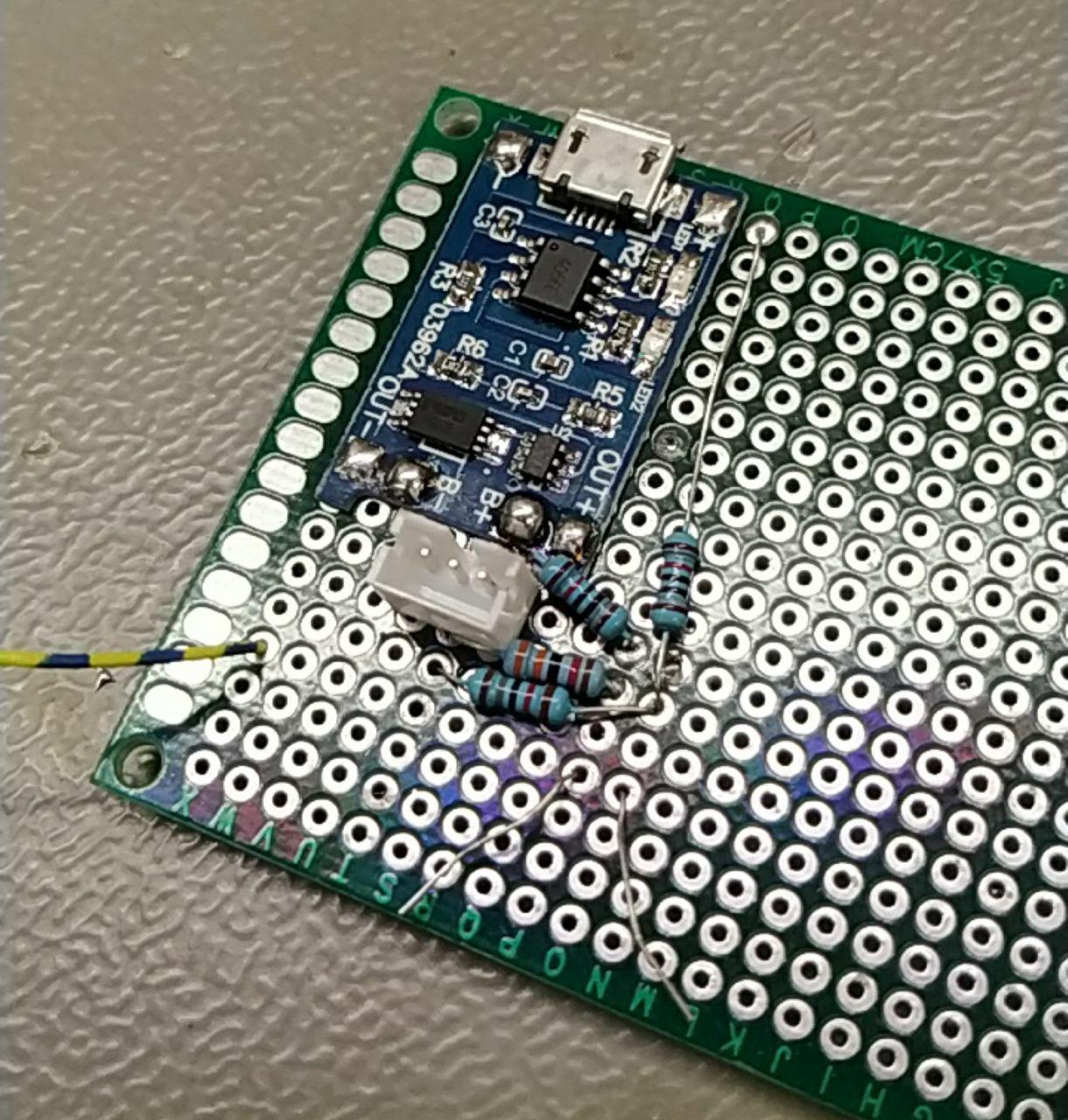 prototype voltage divider, with the lipo module and 4 resistors on a green protoboard